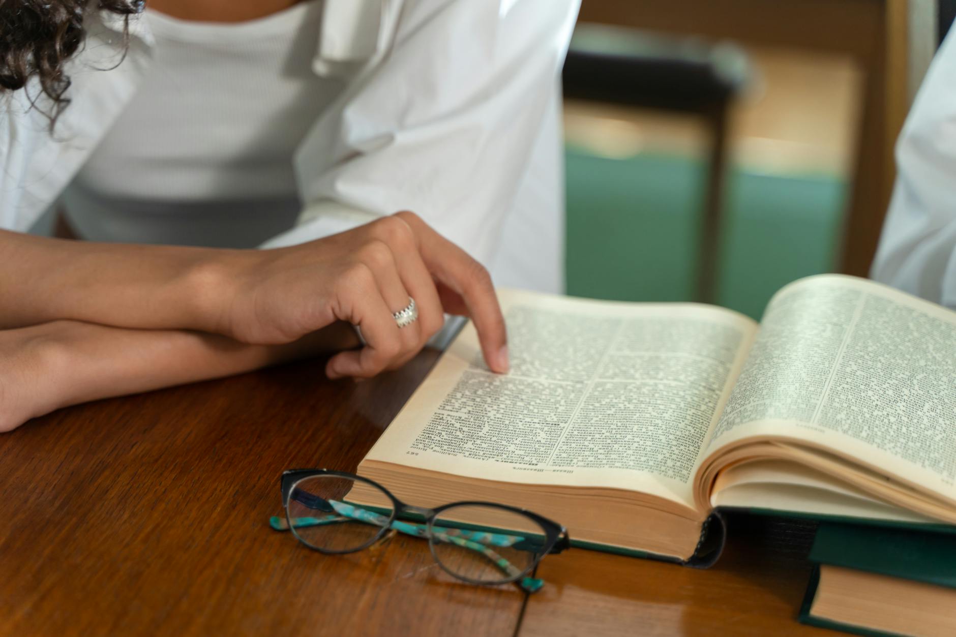 a person s hand pointing at a book
